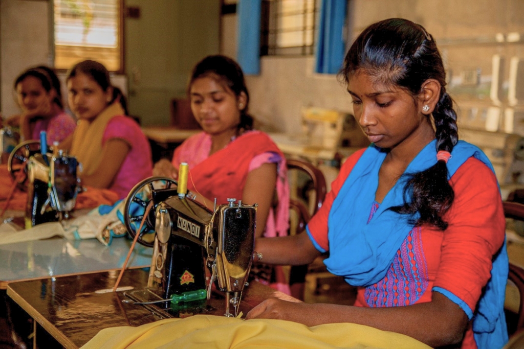 Young girls learning how to sew.